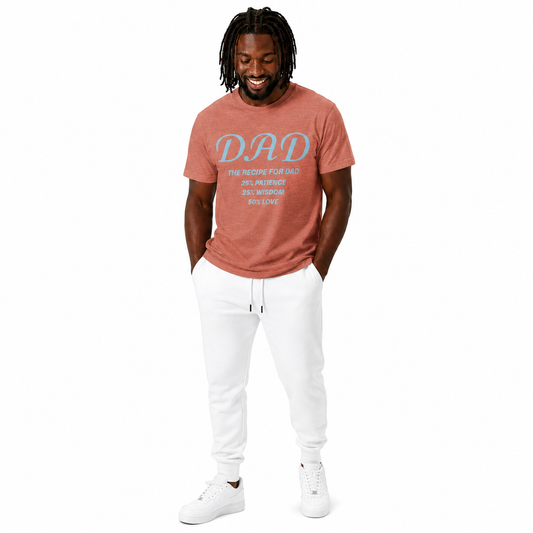 Man wearing a heather clay 'DAD' t-shirt and white pants on a white background