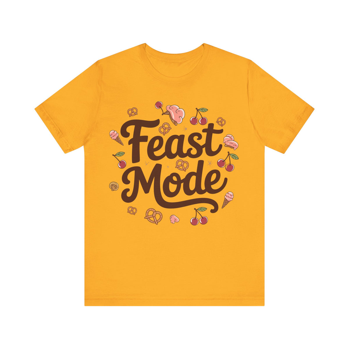 A gold short-sleeve t-shirt with a graphic on the front that reads 'Feast Mode' in dark brown script, surrounded by small illustrations of cherries, ice cream cones, pastries, and pink desserts, displayed on a solid white background.