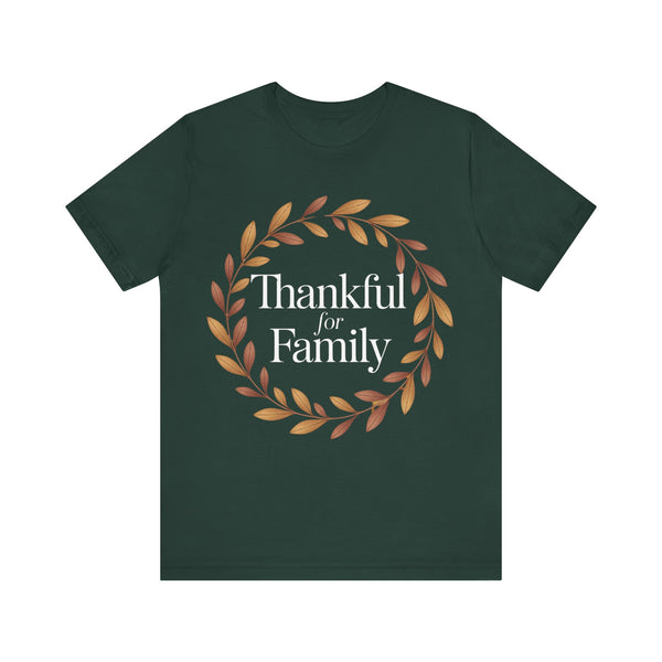 A dark forest green short-sleeve t-shirt with a graphic on the chest featuring a circular wreath of brown and orange leaves surrounding the white serif text 'Thankful for Family'.