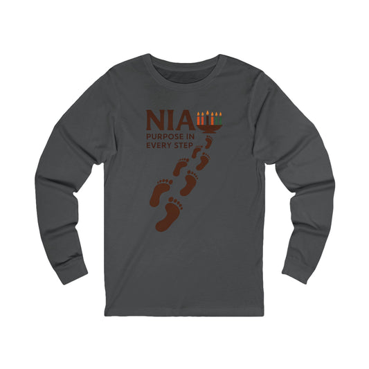 A dark gray long-sleeve t-shirt with a brown graphic on the chest that reads 'NIA PURPOSE IN EVERY STEP' with footprints and candles, shown on a plain white background.