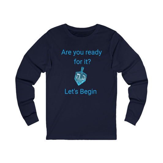 A navy blue long-sleeve t-shirt with a light blue graphic on the front that reads 'Are you ready for it? Let's Begin' with a dreidel illustration, shown on a plain white background.