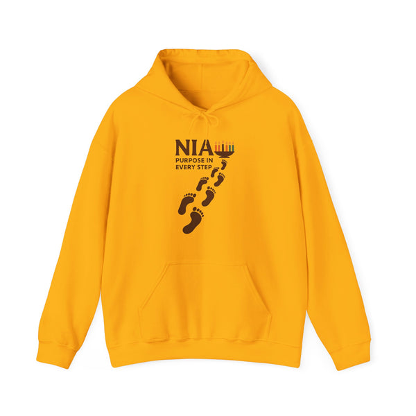 A gold pullover hoodie with a black graphic on the chest reading 'NIA PURPOSE IN EVERY STEP' above a line of footprints, shown on a plain white background.