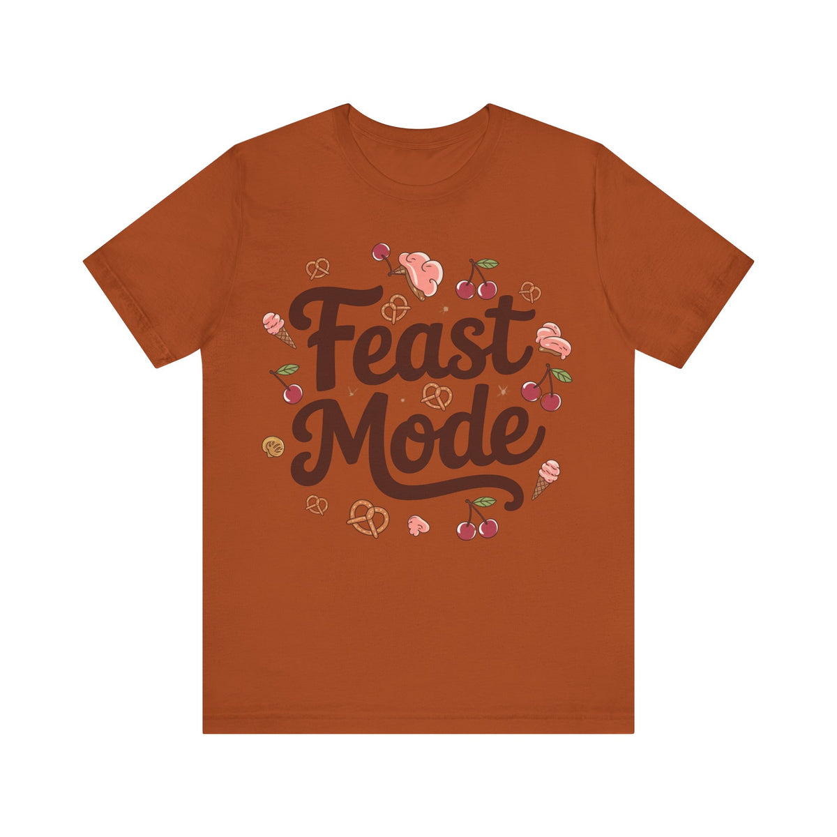 A rust-orange crewneck t-shirt featuring a 'Feast Mode' graphic print in the center with illustrations of pretzels, cherries, and pink snacks.