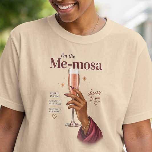 Person wearing a beige t-shirt with a graphic of a hand holding a glass of pink champagne and text.