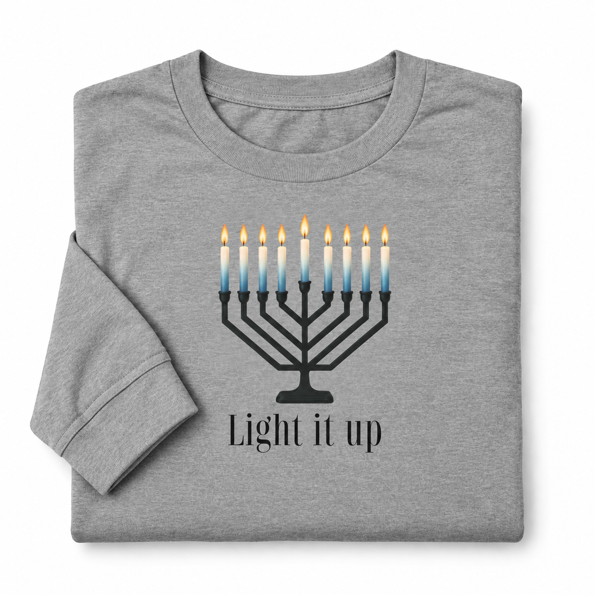 A folded heather gray t-shirt featuring a black menorah graphic with blue-to-yellow gradient candles and the text 'Light it up' printed below.