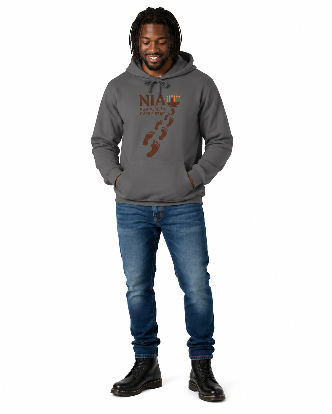 A man wearing a dark gray pullover hoodie with a brown graphic print on the front, paired with blue jeans and black boots, standing against a plain white background.