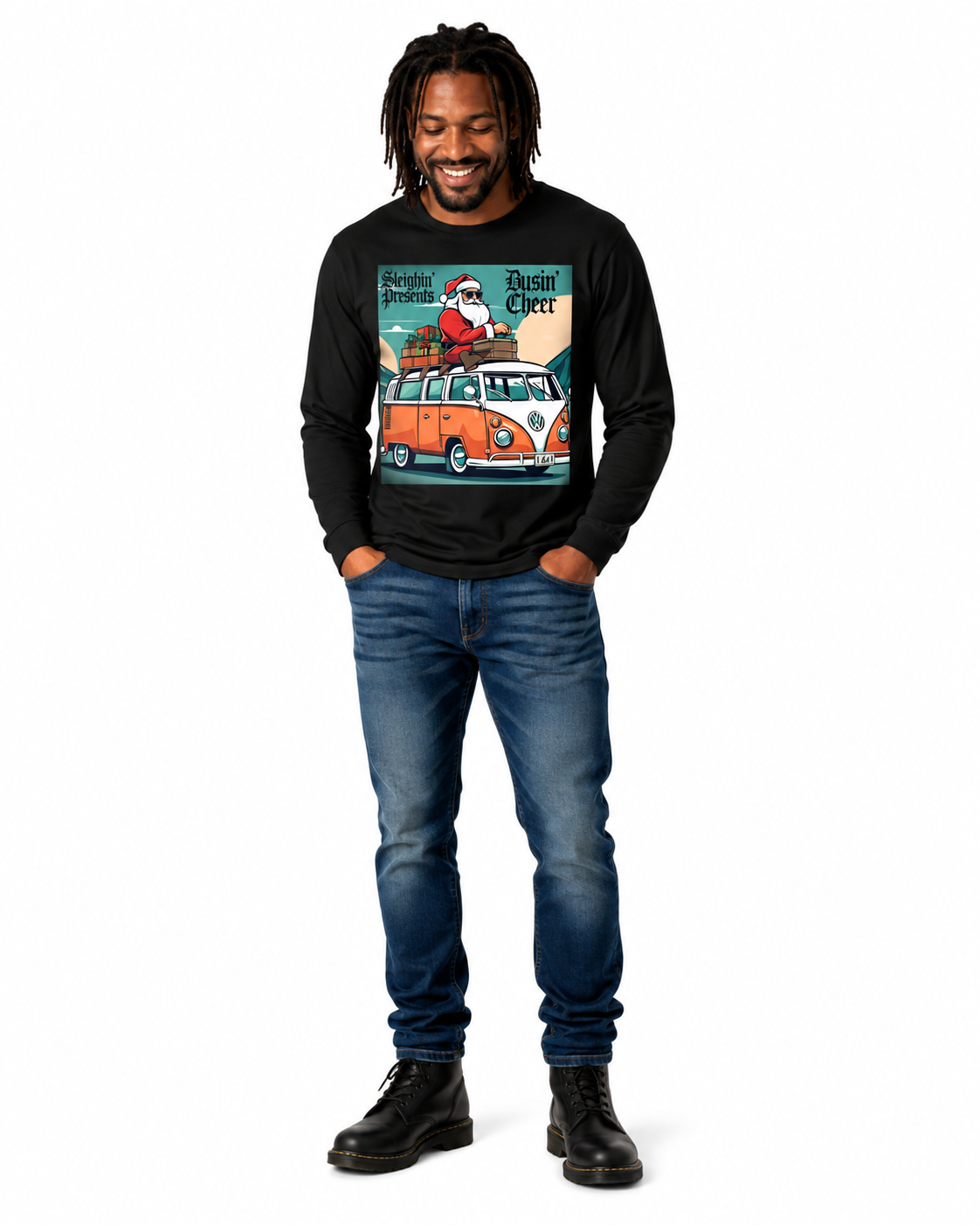 A man wearing a black long-sleeve graphic t-shirt with a vintage Santa Claus and VW bus design, paired with blue jeans and black boots, standing against a plain white background.