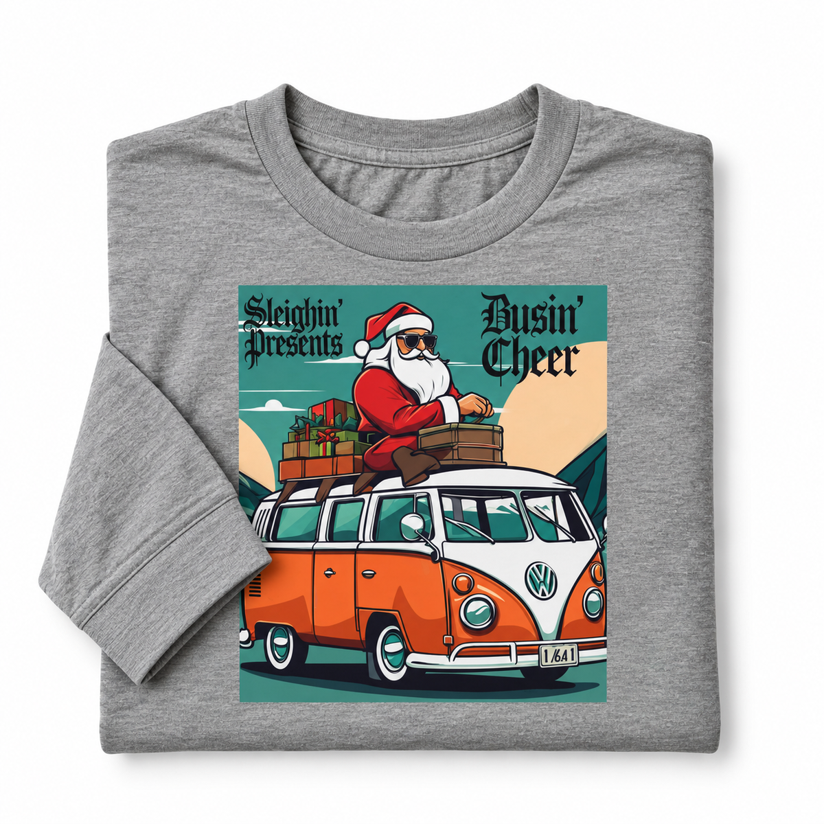 A folded heather gray t-shirt with a long sleeve, featuring a colorful graphic print of a Santa Claus sitting on top of an orange and white VW bus with the text 'Sleighin' Presents' and 'Busin' Cheer'.