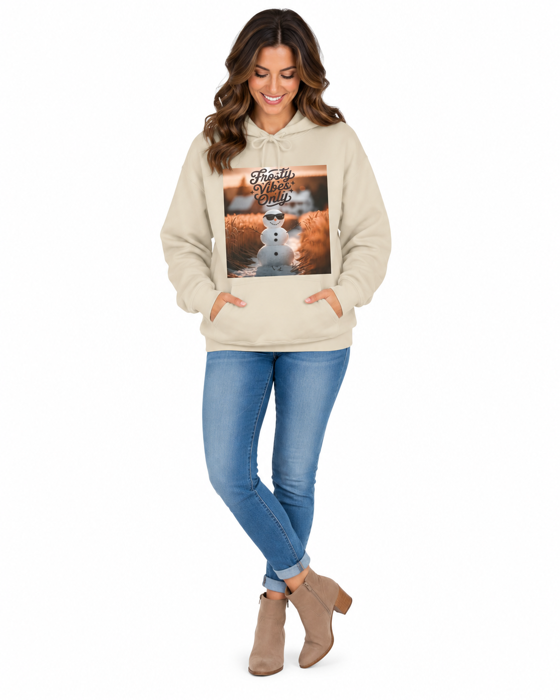 A woman modeling a beige pullover hoodie with a large square graphic print on the front, paired with blue jeans and tan ankle boots, against a plain white background.