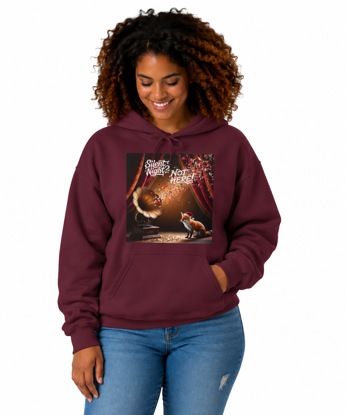 A model in jeans with a maroon pullover hoodie with a square graphic print on the chest. The graphic features a vintage gramophone, a fox, and the text 'Silent Night? NOT A HERE!'.