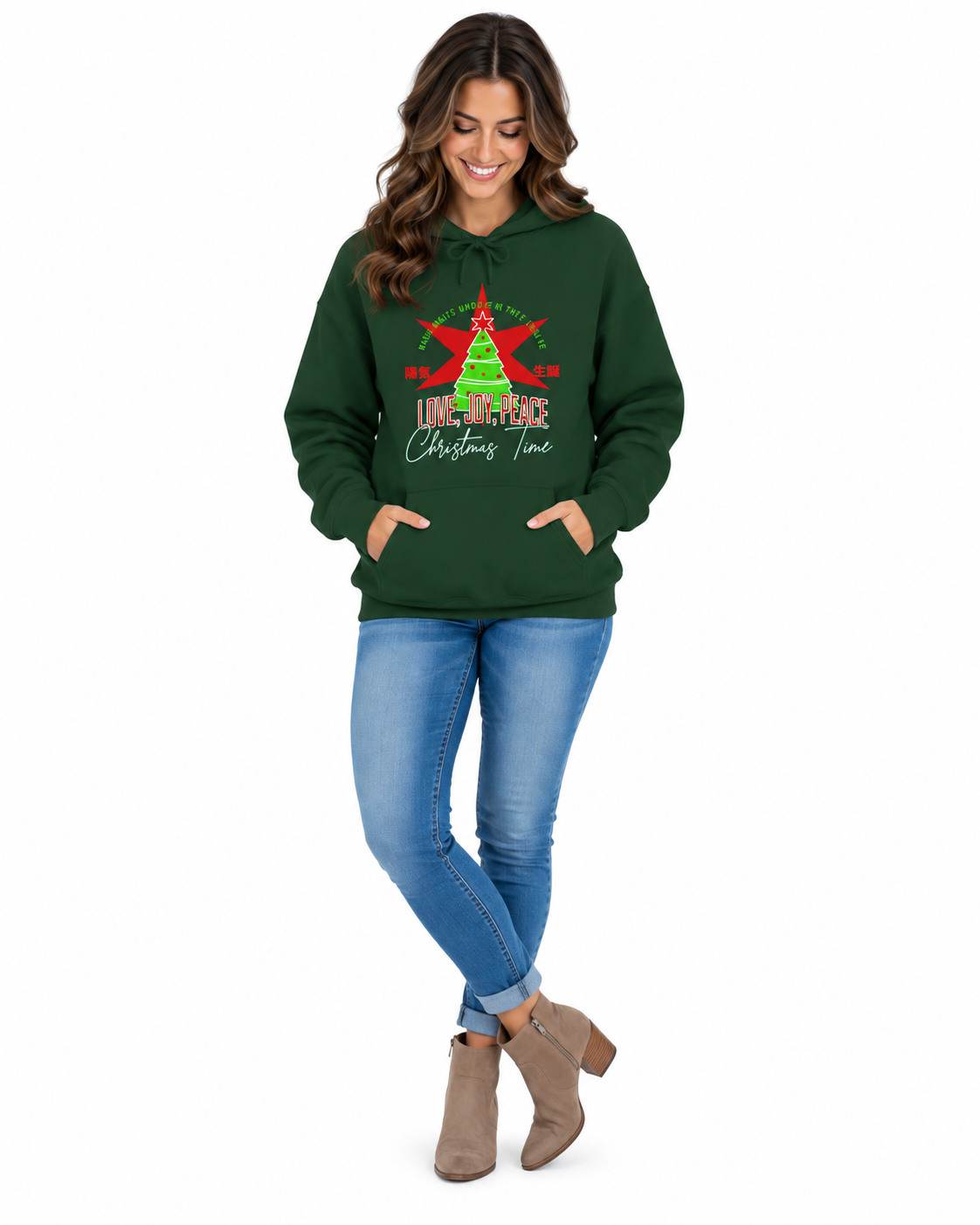 A female model with dark green hoodie with a Christmas graphic on the chest, featuring a green tree, red star, and the text 'LOVE, JOY, PEACE Christmas Time' on a plain white background.
