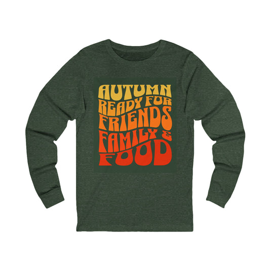 A dark heather green long-sleeve t-shirt with a retro-style graphic on the chest that reads 'AUTUMN READY FOR FRIENDS, FAMILY & FOOD' in a vertical stack of yellow, orange, and red wavy letters, shown against a plain white background.