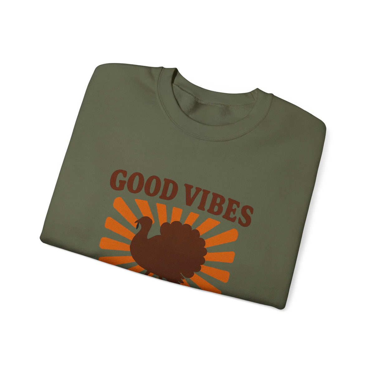 An olive green folded t-shirt with a brown turkey graphic and the words 'GOOD VIBES' in brown text over an orange sunburst design, shown on a plain white background.