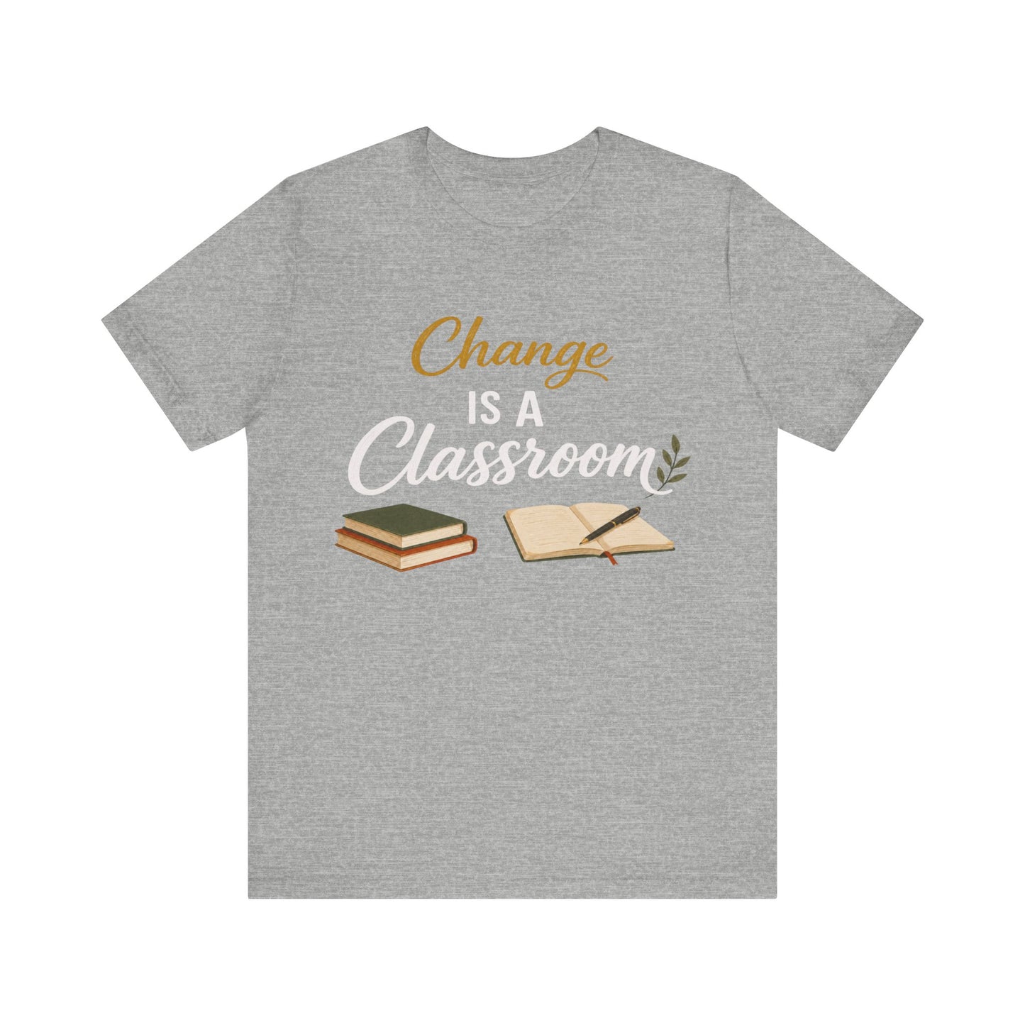 A heather gray short-sleeve t-shirt with a graphic print on the front that reads 'Change IS A Classroom' in white and gold lettering, accompanied by illustrations of stacked books and an open notebook with a pen.