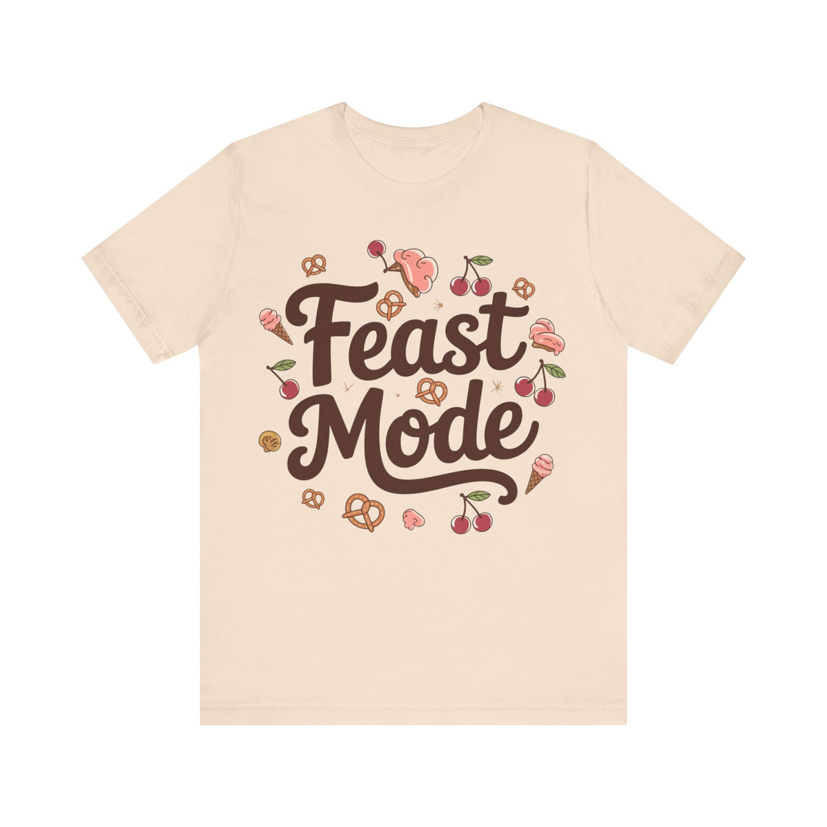 A cream crewneck t-shirt featuring a 'Feast Mode' graphic print in the center. The graphic displays the words 'Feast Mode' in a dark brown cursive font, surrounded by cute illustrations of food items like cherries, pretzels, ice cream cones, and pink desserts.