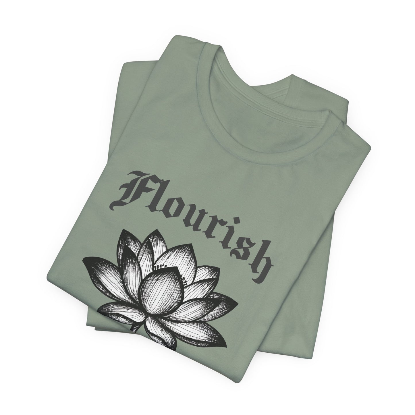 Folded sage green t-shirt with 'Flourish' text and lotus flower design on a white background