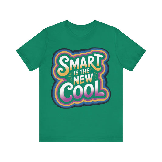 A green short-sleeve crewneck t-shirt featuring a colorful retro-style graphic on the chest that reads 'SMART IS THE NEW COOL' in white, yellow, orange, pink, and blue gradient lettering.