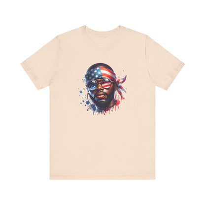 Cream t-shirt with a graphic of a face wearing an American flag bandana on a white background