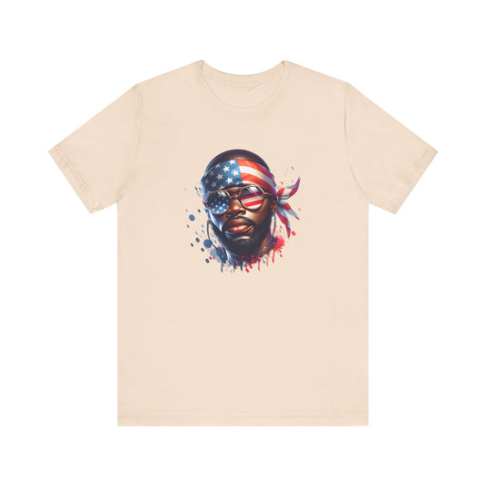 Cream t-shirt with a graphic of a face wearing an American flag bandana on a white background